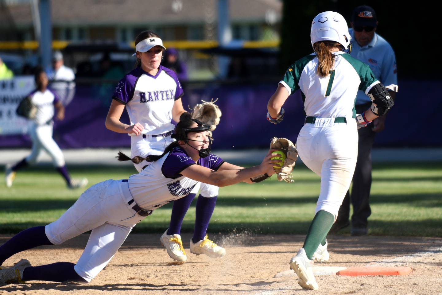 Manteno's Maddy Delya, left, dives in attempt to tag Coal City's Rese Symons out at first base during the Class 2A Manteno Regional semifinals Wednesday, May 20, 2026.