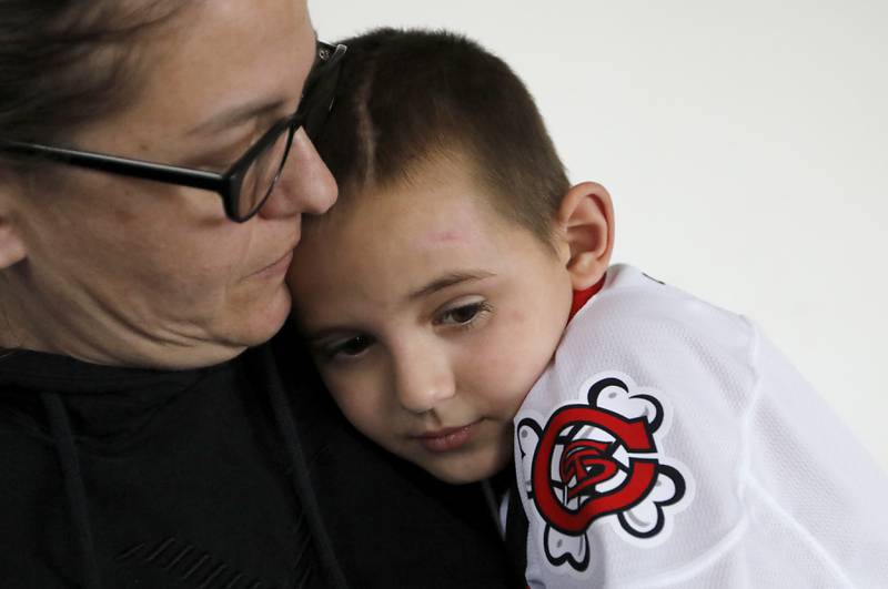 Alex Moscrip, 7, the son of Brad and Aleksandra, with his mon on Wednesday. Nov 13, 2024 at his home in McHenry Township. Hewas hit by a car in July and left with traumatic brain injury and is now recovering at home.