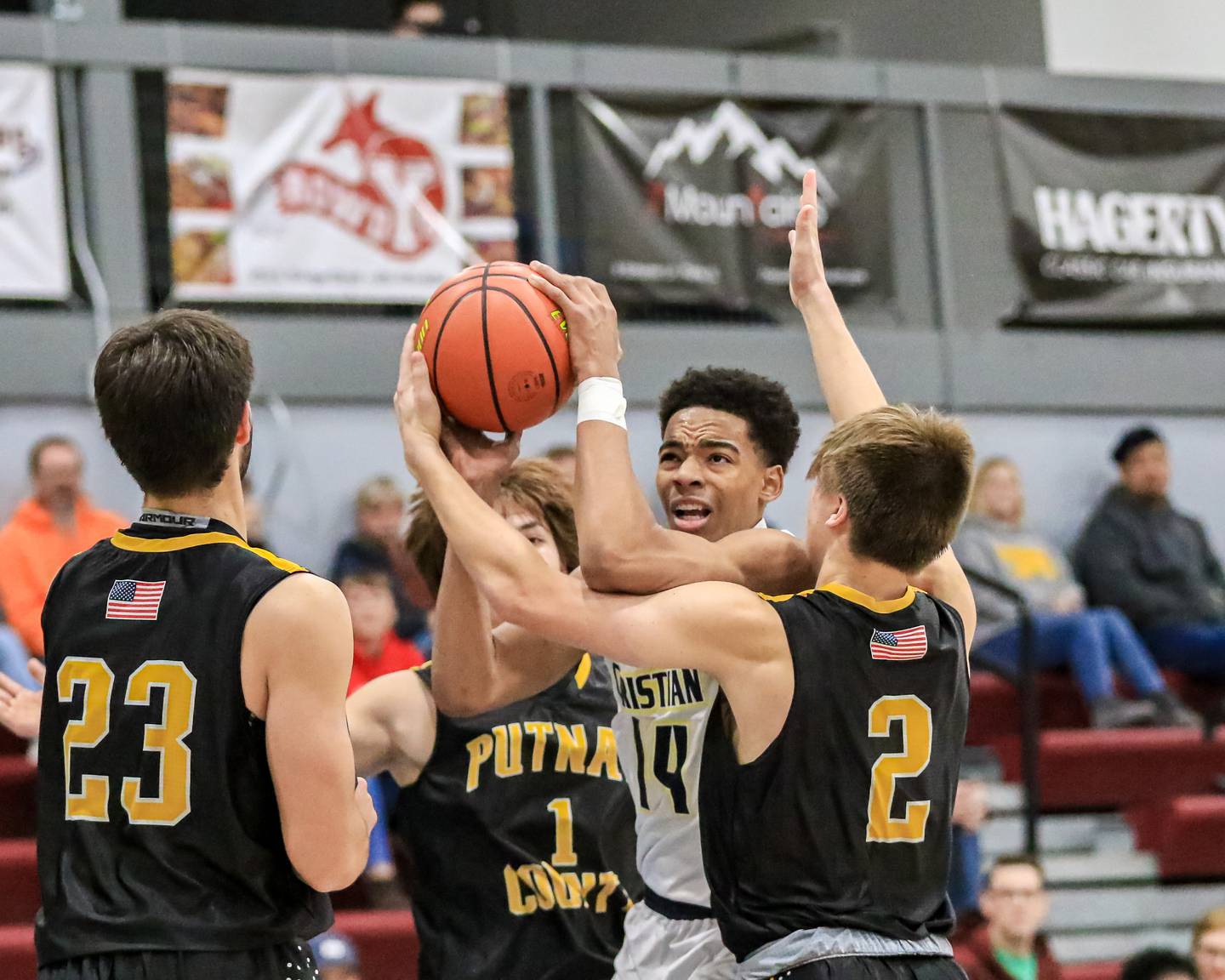 Yorkville Christian's David Douglas, Jr. (14) is surrounded by Putnam County players on a drive to the basket during varsity basketball game between Putnam County vs Yorkville Christian. Dec 21, 2022.