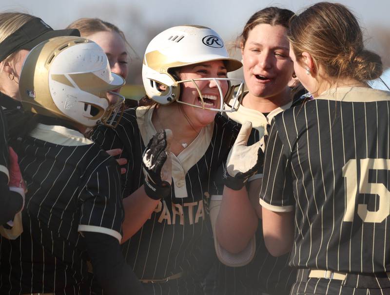 Sycamore's Kairi Lantz is congratulated by her teammates at home plate after hitting a two-run homer Friday, April 11, 2025, during their game against Marengo at Sycamore High School.
