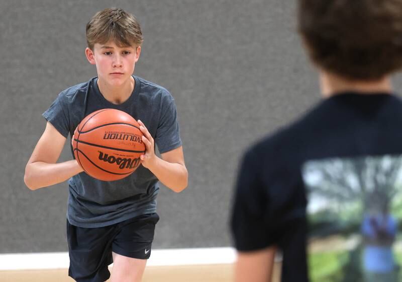 Caleb Krueger, (left) 13, and his brother Cole, 15, from Genoa, show off the passing technique Wednesday, Aug. 28, 2024, that earned them the Guinness World Record record for the most basketball passes in a minute for a pair under 16. The two are planning an attempt at breaking the world record for the most three pointers in a minute by a duo.