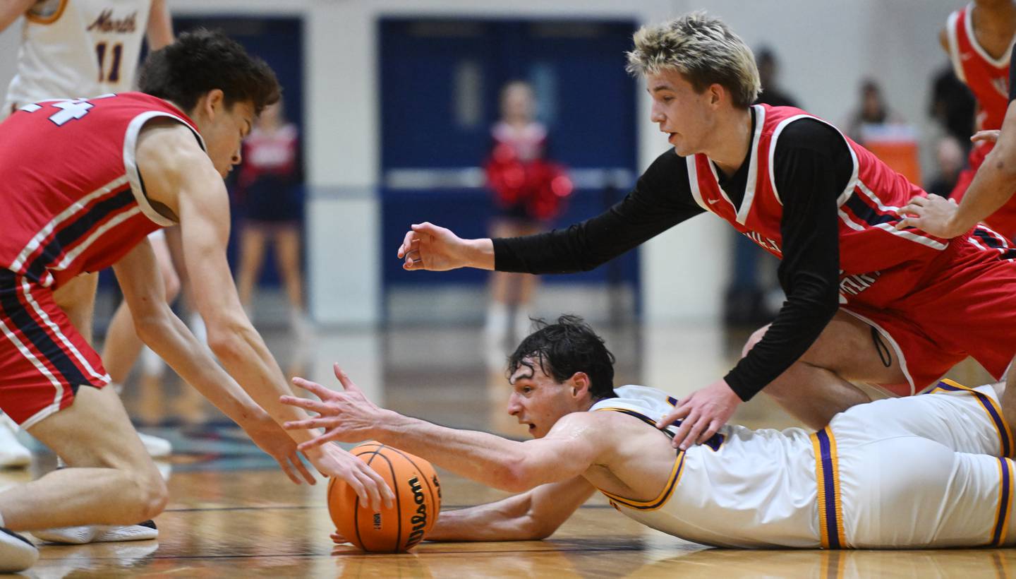 Downers Grove North's Aidan Akkawi dives for a loose ball between West Aurora's Gabriel Gonzales, left, and Kael Adkins during the Class 4A Downers Grove South regional final on Friday, Feb. 28, 2025 in Downers Grove.