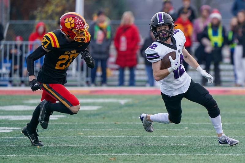 Downers Grove North's Max Troha (12) runs after the catch against Batavia’s Andrew Culotta (27) during a class 7A quarterfinal playoff football game at Batavia High School on Saturday, Nov. 16, 2024.