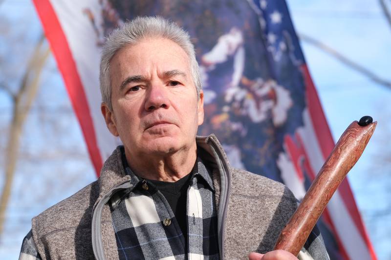 David Kump stands with his scared walking stick. David is on on a one-man mission to make people aware of the anniversary of the massacre at Wounded Knee and Native American history. Wednesday, Dec. 22, 2021 in Joliet.