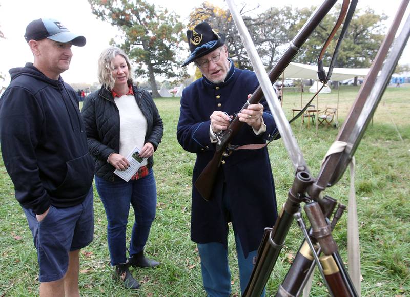 Greg Cole, of Crystal Lake (on right) talks with Tim Bress, of McHenry and Katie Reynolds, of Grayslake about an 1853 Model Enfield rifle-musket during Hainesville’s Civil War Encampment & Battle at the Northbrook Sports Club on October 21st in Hainesville. 
Photo by Candace H. Johnson for Shaw Local News Network