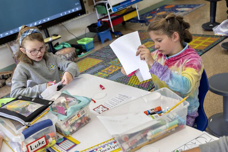 St Anne’s third grader Isis Wakenight (left) and second grader Addy Root cut out work sheets during their STREAM session at the school. The science, technology, religion, engineering, arts and math exercises were all apple-themed.