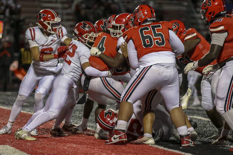 Bolingbrook's Timmie Lewis II (4) backs into the endzone for a touchdown during football game between Yorkville at Bolingbrook Friday, Oct 24, 2025 in Bolingbrook.