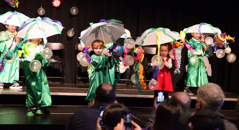 Pictured are some of the Woodlawn Arts Academy preschool graduates performing a dance to their graduation theme song, “Octopus’s Garden” by Ringo Starr while parents and grandparents capture the moment on their phones.
