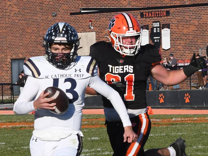 Elmhurst IC Catholic quarterback Nate Lang runs to escape Byron defender Kade Politsch (61) during 3A quarterfinals  on Saturday, Nov. 15, 2025 at Byron High School.