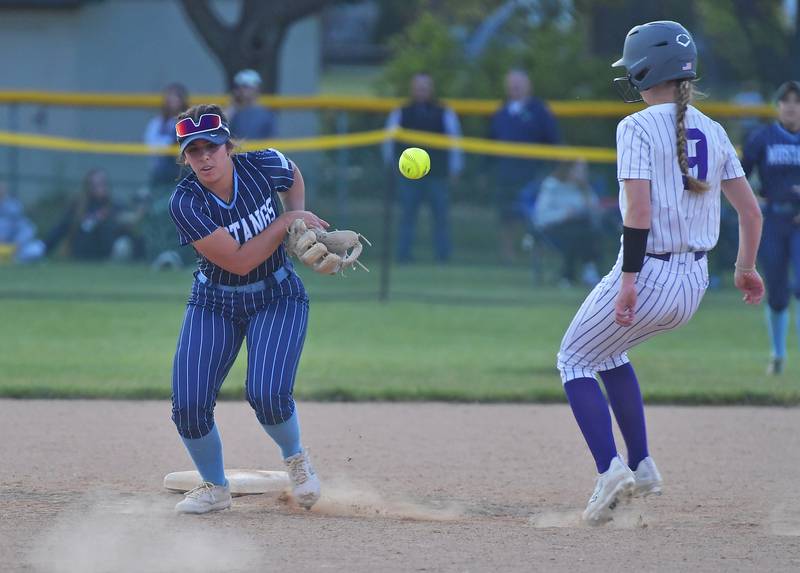 Downers Grove North’s Emma Sondgeroth arrives at second base as Downers Grove South’s Natalia Manganello struggles with a bad hop during a game on May 14, 2026 at McCollum Park in Downers Grove .