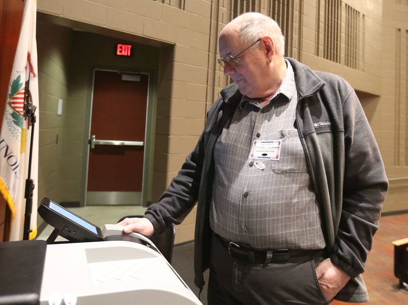 Election Judge Victor Crosdale adjusts the voting maching on Tuesday, March 17, 2026 at Hall High School in Spring Valley.