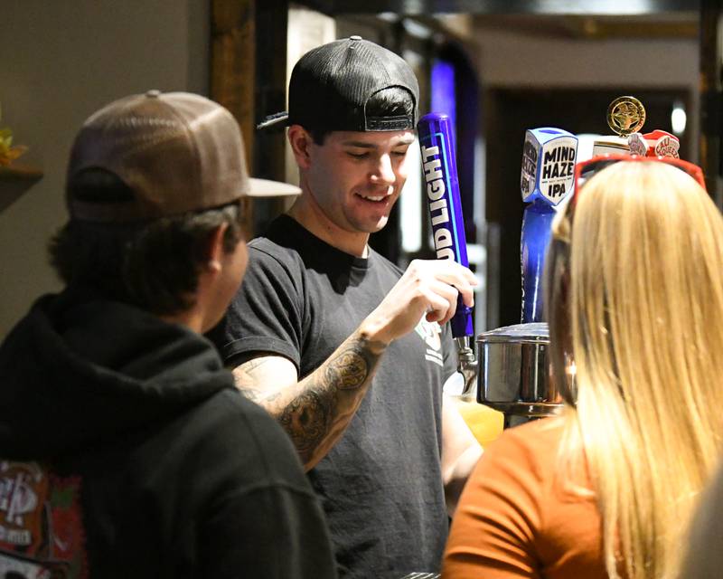 Firefighter Brennan Peters fills drinks on Wednesday, Nov. 27, 2024, at Fatty's Pub and Grille in DeKalb during the DeKalb Fire Fighters Local 1236 union's Tip A Firefighter event to fundraise for the Muscular Dystrophy Association.