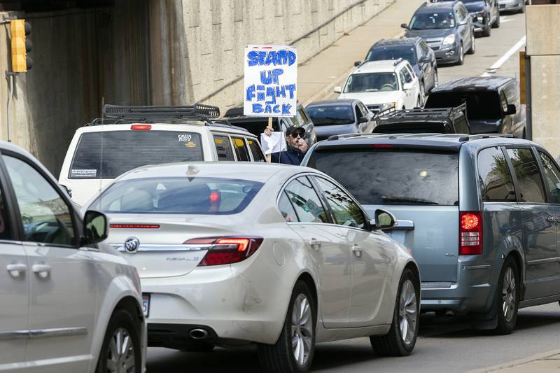 Stephen Nalder stops traffic on First Avenue into Sterling Saturday, May 3, 2025, to allow his protesters to cross the street onto Wallace. Nalder runs the group Indivisible SRFD (Sterling, Rock Falls, Dixon) that protests the Trump administration.