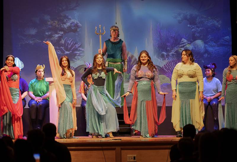 King Triton, played by Lucas Outzen, lords over a scene with his daughters Friday, April 26, 2024 during Fulton High School’s “The Little Mermaid.”