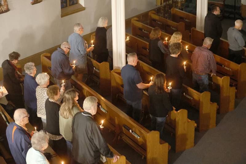 Parishioner light candles during Holy Thursday Mass on Thursday, March 2, 2026 at St. Mary's Catholic Church in Utica.