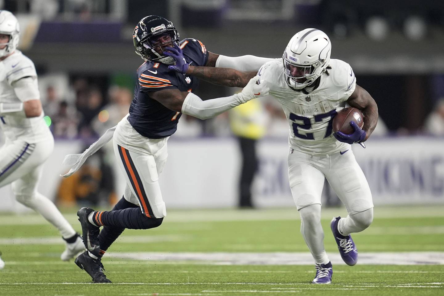 Minnesota Vikings running back Cam Akers (27) tries to break a tackle by Chicago Bears cornerback Jaylon Johnson (1) during the second half of an NFL football game, Monday, Dec. 16, 2024, in Minneapolis. (AP Photo/Abbie Parr)