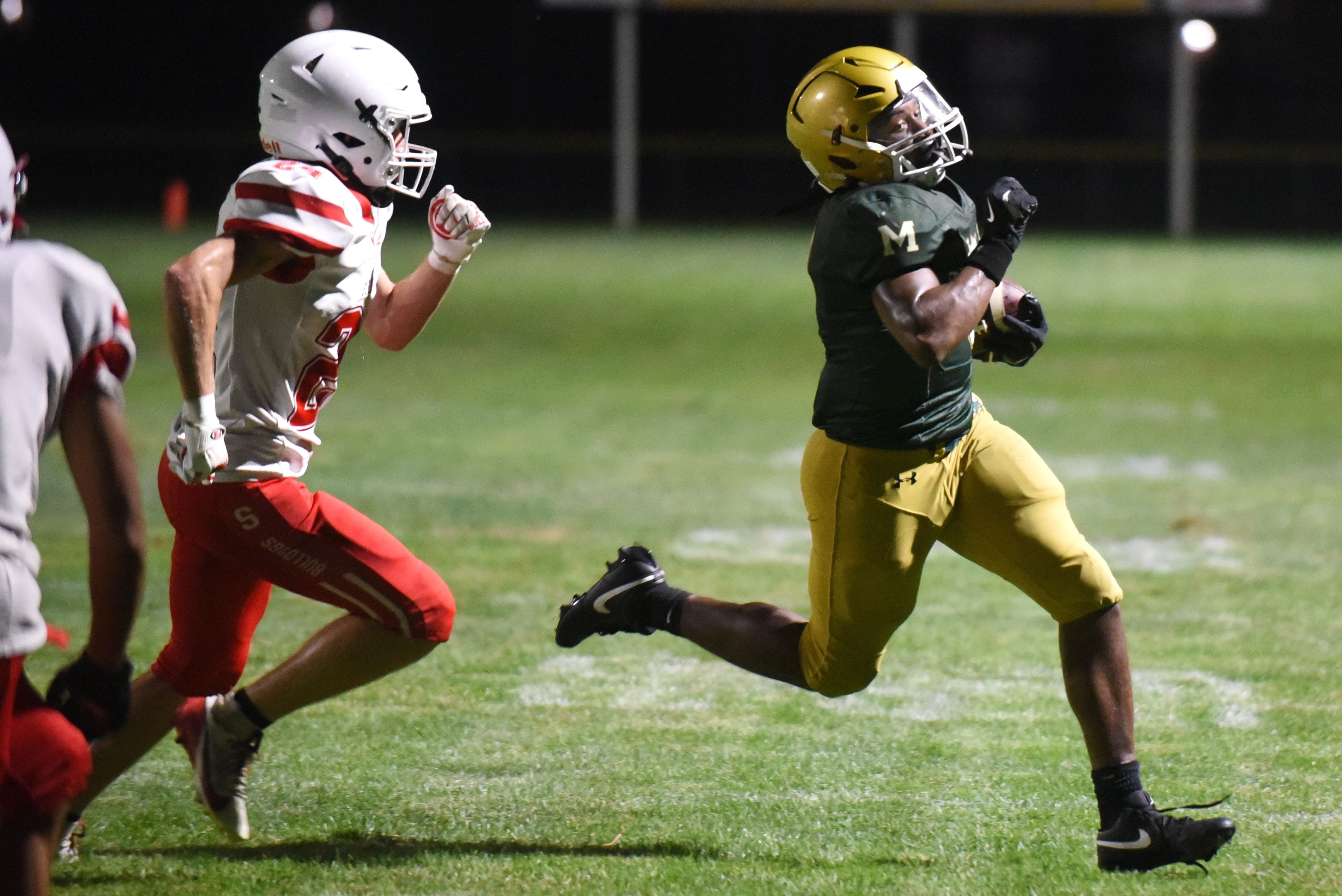 Bishop McNamara's Julius May (right) runs past Streator's Quentin Stevens during a Week 0 scrimmage on Friday, August 22, 2025, at Bishop McNamara.