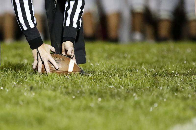 A referee places the football down at the line of scrimmage during the football game between Jacobs and Hampshire at Jacobs High School on Friday, Oct. 15, 2021 in Algonquin.