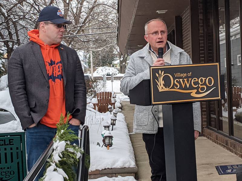 Oswego Village President Ryan Kauffman, left, listens as State Rep. Matt Hanson, D-Montgomery, speaks during a Dec. 3 ceremony marking the opening of an ADA ramp on Main Street in downtown Oswego. Hanson helped secure the funding for the project.