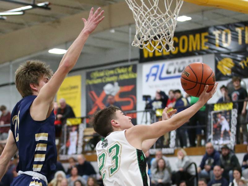 Seneca's Brady Sheedy does a reverse layup over Marquette's Logan Nelson during the Tri-County Conference championship game on Friday, Jan. 27, 2023 at Putnam County High School.