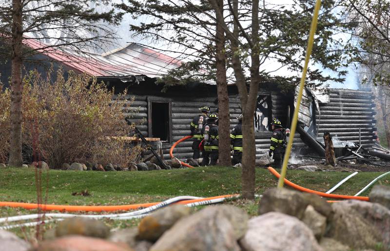 Firefighters continue to work on a smoldering house that was destroyed by fire Thursday, Nov. 13, 2025, near Shabbona Grove Road in Shabbona. Several local departments responded to the general alarm structure fire.
