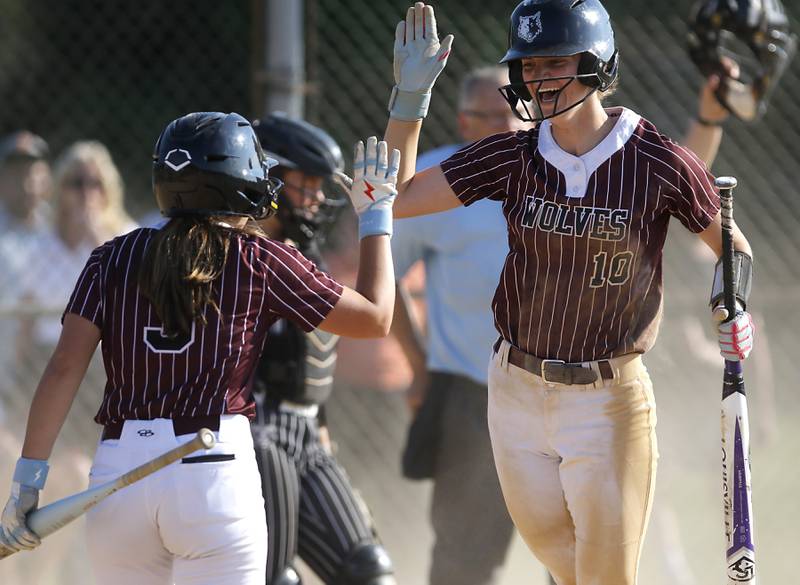 Prairie Ridge's Kylie Carroll (left) celebrates scoring a run during a Fox Valley Conference softball game against Crystal Lake Central on Wednesday, May 14, 2025, at Crystal Lake Central High School.