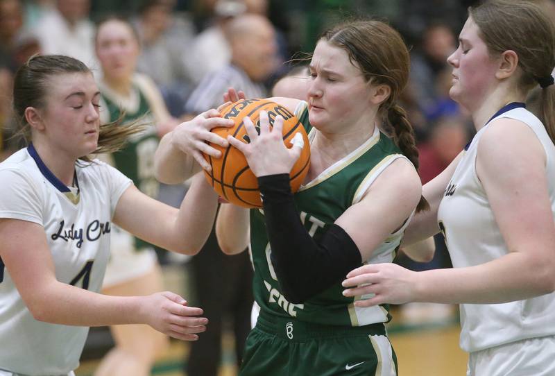 St. Bede's Lili McClain grabs a rebound over Marquette's Hunter Hopkins and Kelsey Cuchra during the Class 1A Regional semifinal game on Tuesday, Feb. 18, 2025 at St. Bede Academy.