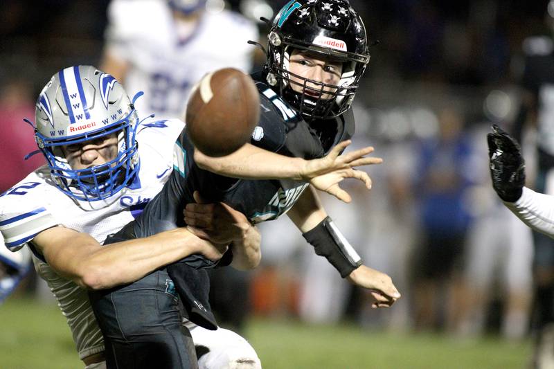 Woodstock North’s Landan Creighton flips the ball away as Woodstock’s Zachary Canaday closes in for a tackle in varsity football at Woodstock North Friday night. Creighton successfully hit teammate Parker Halihan with the flipped pass for a first down.