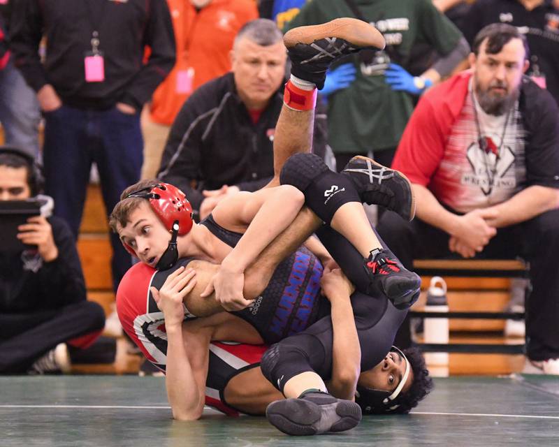Logan Conover of Marmion Academy, front and Waleed Binmahfooz of Glenbard East wrestle where Logan took the regional win in the 106 weight class on Saturday Feb. 3, 2024, held at Glenbard West High School.