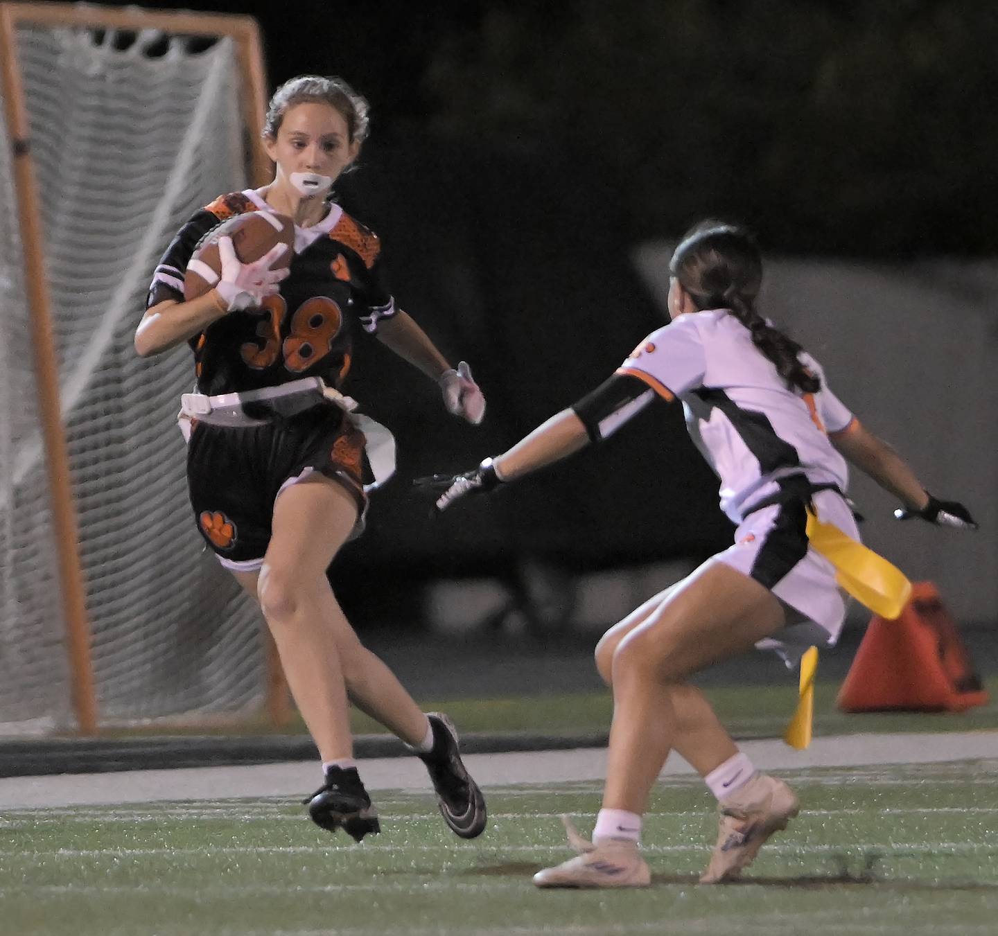 Wheaton Warrenville South’s AJ Zielinski runs an interception back as St. Charles East’s Leah Arroyo tracks her down in a flag football game in Wheaton on Monday, Sept. 8, 2025.