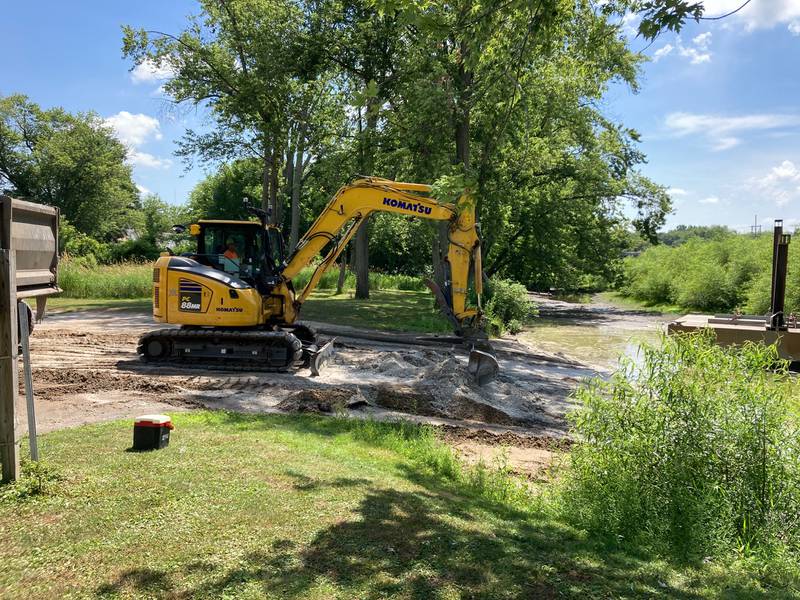 An employee of JS McCullough Excavating removes sand from the Aroma Park boat launch on Thursday.