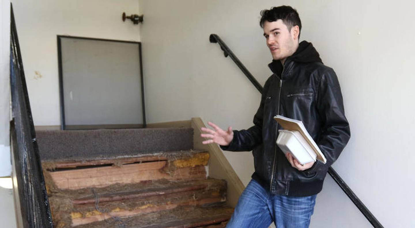 James West, 24, a junior at Northern Illinois University and resident of Ridgebrook Apartment Complex in DeKalb, which is owned by Hunter Properties, talks Friday about the torn up carpet in a stairwell of one of the buildings and how long it has sat in disrepair. West is part of an effort to form an association of tenants of Hunter Properties buildings in hopes that it will help get some of the problems remediated in a timely manner.