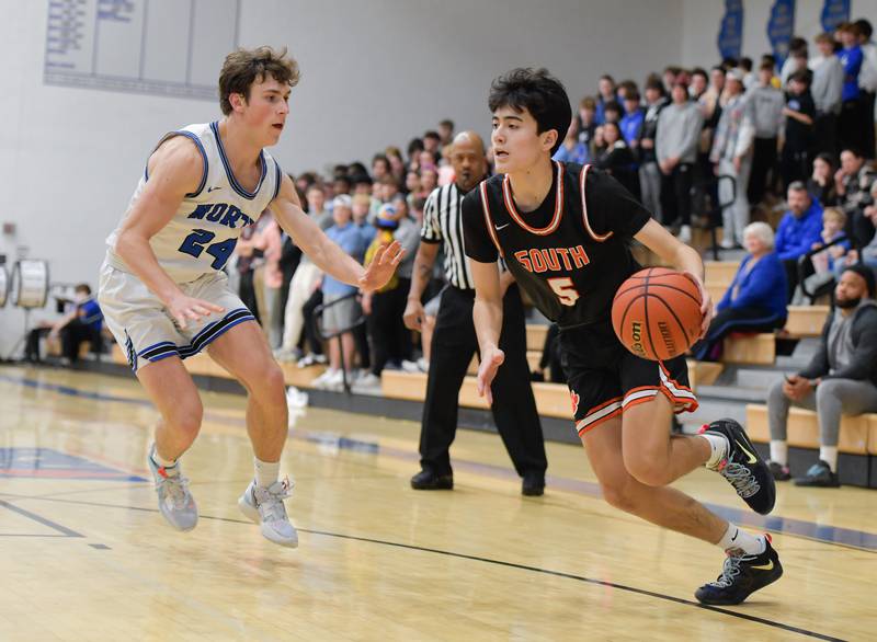 Wheaton Warrenville South Brody Canfield (5) drives around St. Charles North's Colin Ross (24) during a game on Friday, December 2, 2022.