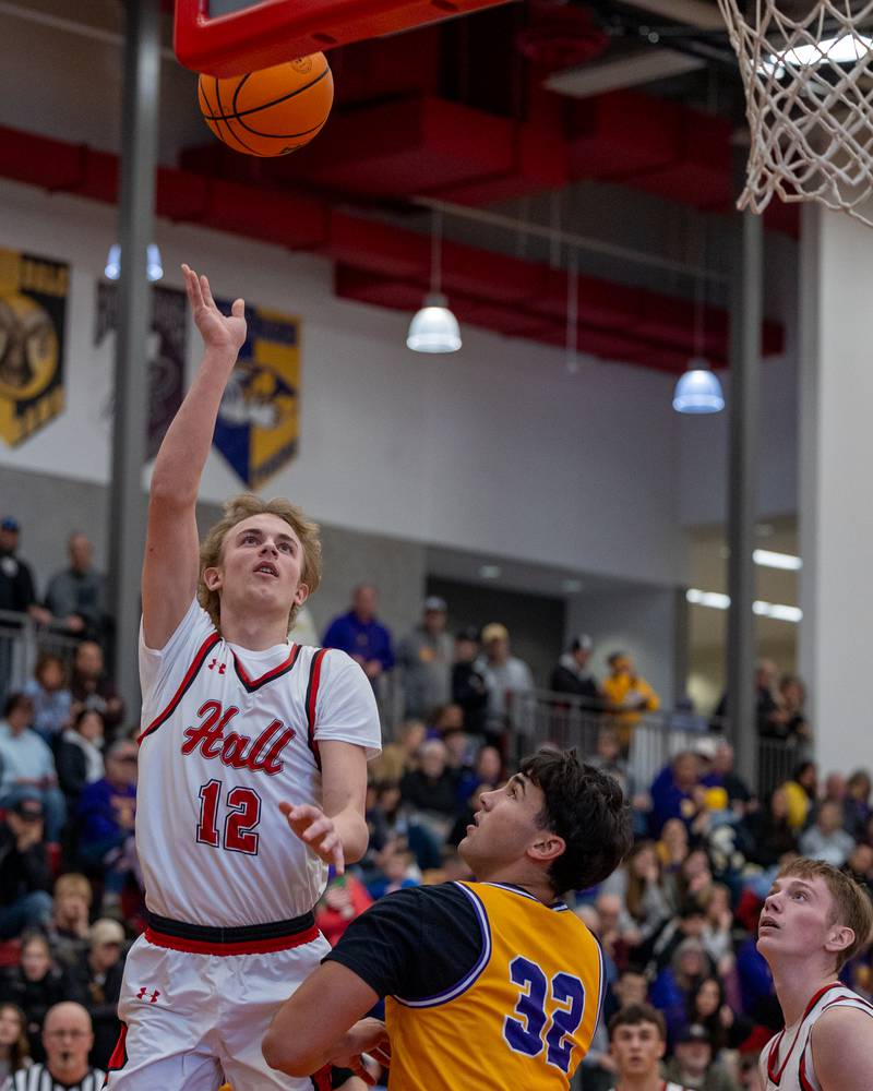 Hunter Edgcomb (12) of Hall lays ball up over Cam Wasmer (32) of Mendota in championship game of the Colmone Classic on Saturday, December 20, 2025 at Hall High School in Spring Valley.