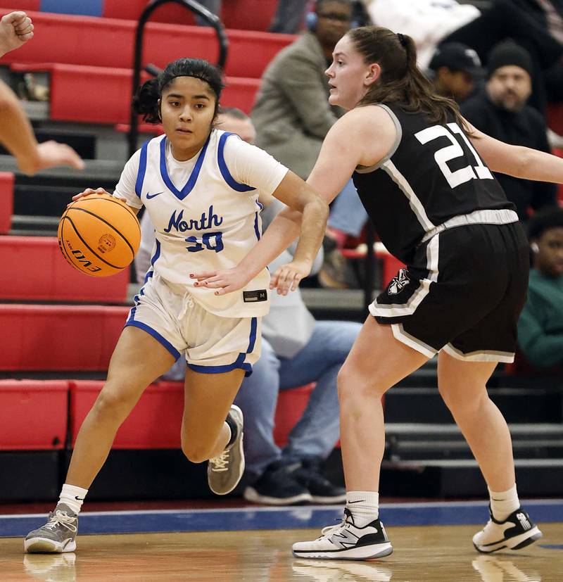 St. Charles North's Lelanie Posada (30) slides past Fenwick's Grace Masterson (21) during the Dundee-Crown High School 41st Annual Komaromy Classic Friday, Dec. 27, 2024 in Carpentersville.