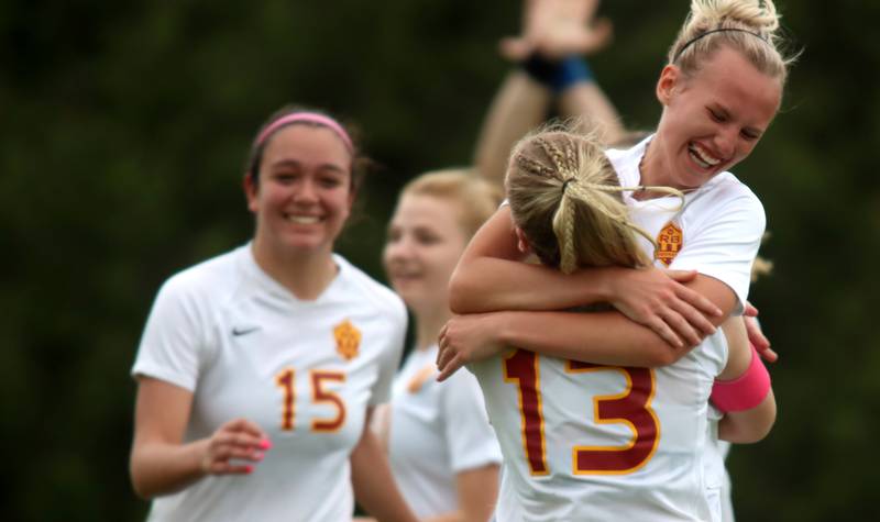 Richmond-Burton’s Layne Frericks, right, hugs teammate Jordan Otto, #13, as Brianna Maldonado, left, enjoys the moment after Frericks scored a second-half goal against DePaul Prep during sectional title game action at Marian Central in Woodstock Friday evening.