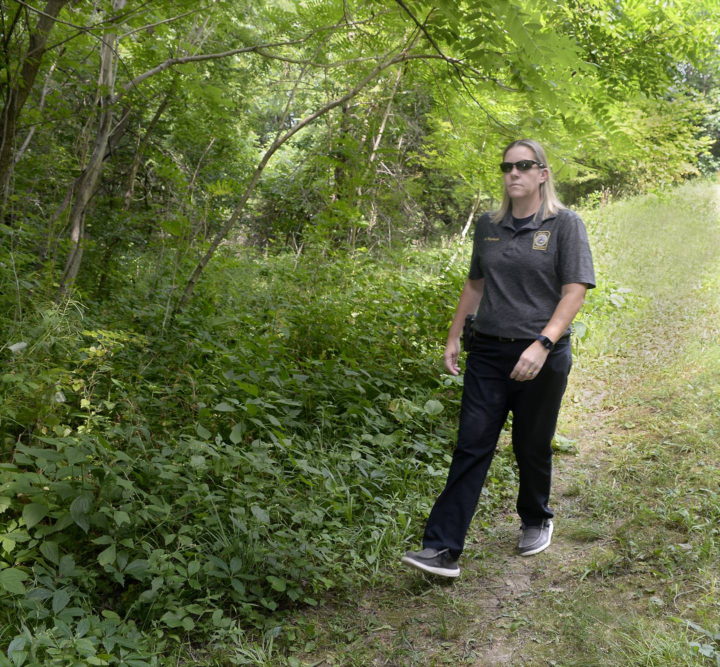 Peru Police Chief Sarah Raymond walks past the wooded area where the car belonging to Jelani Day was found a few hundred feet from the Illinois Valley YMCA