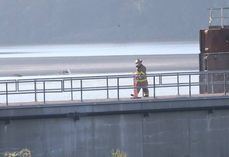 A firefighter walks across the Starved Rock Lock and Dam to help fight a fire inside the Starved Rock hydroelectric power plant at the Starved Rock Lock and Dam on Tuesday, Oct. 3, 2023 near Utica. A MABAS box alarm was sent out just before 730a.m. for a working fire inside the plant.