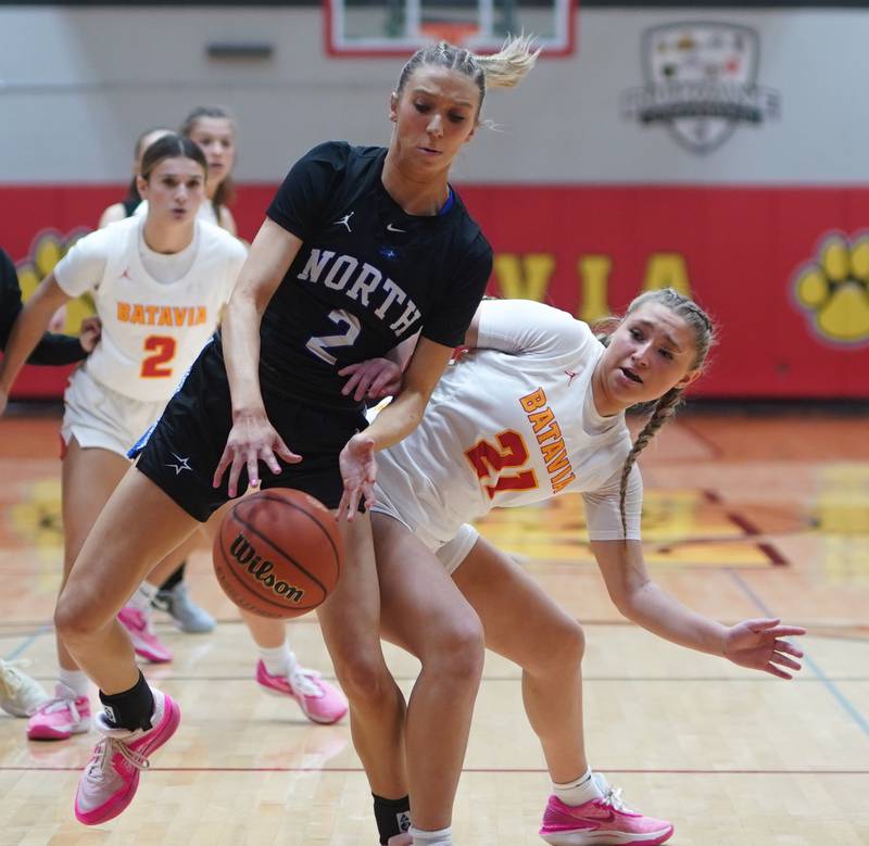 St. Charles North's Reagan Sipla (2) and Batavia’s Kylee Gehrt (21) battle under the basket for a rebound during a basketball game at Batavia High School on Tuesday, Dec 5, 2023.