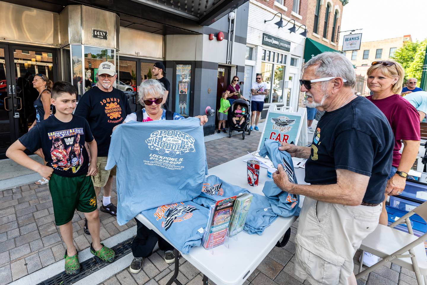 (L:R) Lockport residents Seth Cole, Dick Cole, and Kelly Bourne purchase a shirt from Cruisin' Into Lockport volunteers Jim Nevels and Julie Krejczyk on June 3, 2024.