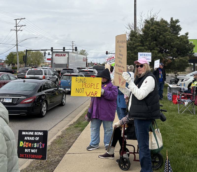 Protestors hold up signs during a May 1 protest in McHenry Friday May 1, 2026.