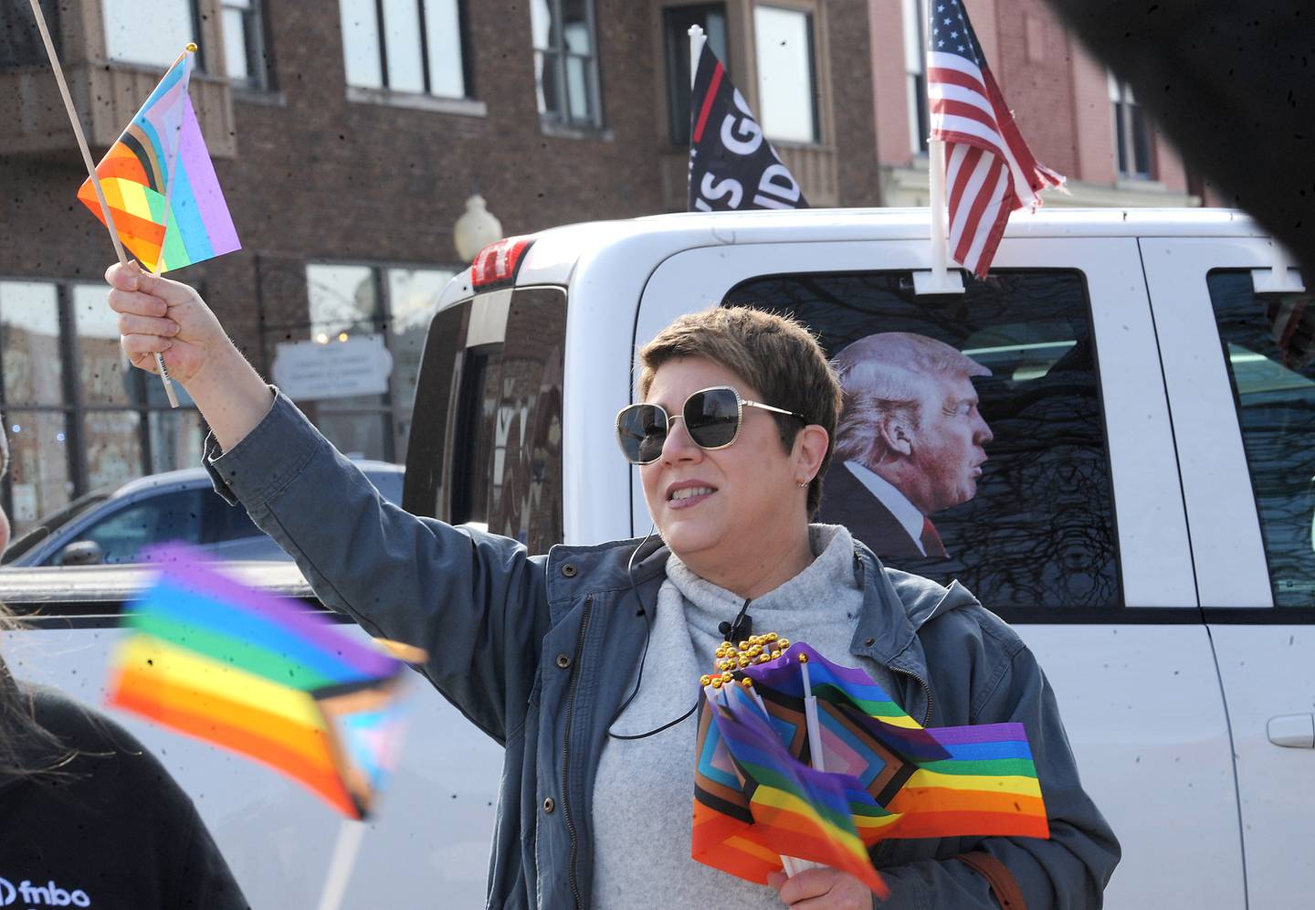 LGBTQ supporter Laura Bobrowsky waves at drivers, while handing out pride flags in front of the Sandwich Opera House on Saturday, Feb. 18, 2023.