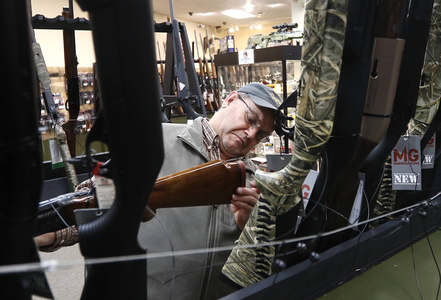 Jeff Norris, of Caledonia, looks at a shotgun Wednesday, Jan. 18, 2023, at Marengo Guns. The McHenry County gun shop is among a group of plaintiffs challenging the constitutionality of Illinois’ ban on semiautomatic weapons and large-capacity magazines that took effect last week.
