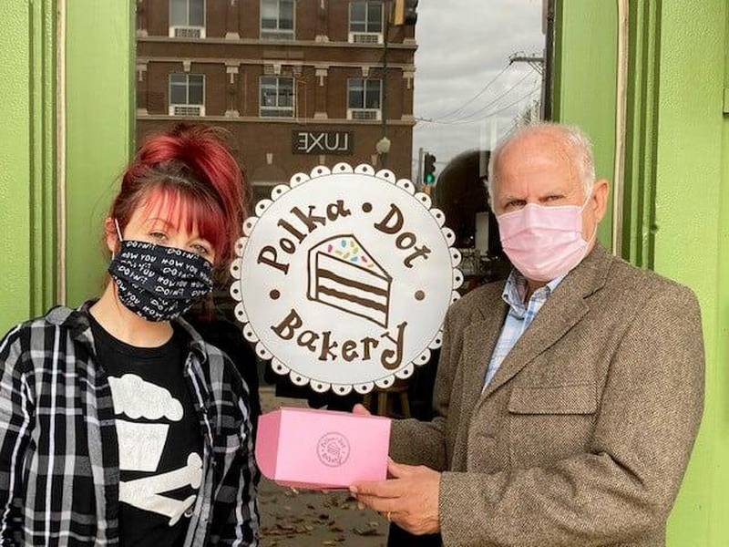 Sycamore Mayor Curt Lang (right) poses with a gift certificate to Polka Dot Bakery as part of the city's #OurTownChallenge on social media.