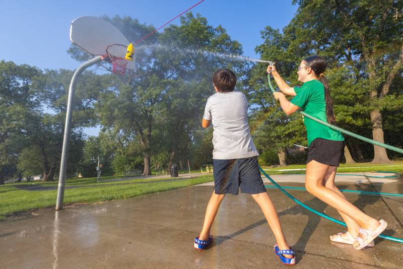 Oliver Jones (right) wins the firefighters water battle by pushing a can down a string with water to her opponent's side during National Night Out on Aug. 5, 2025, in Seneca.