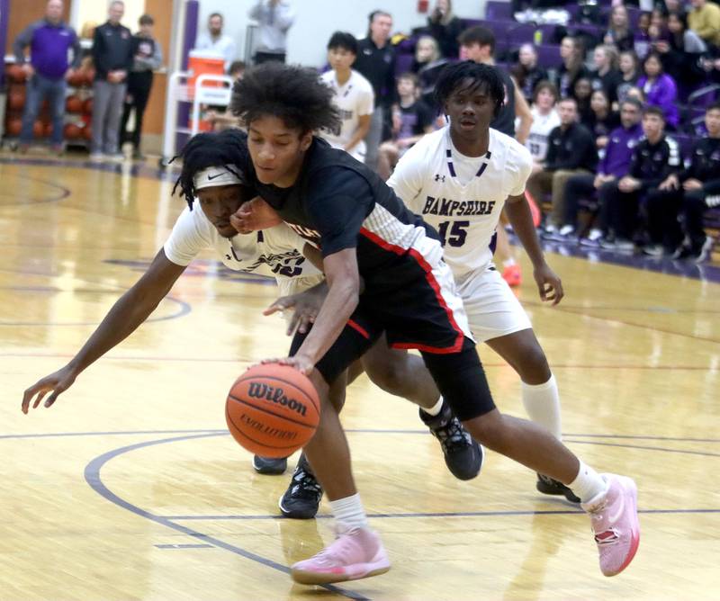 Huntley’s Omare Segarra, front right, dribbles as Hampshire’s Aman Adeshina, left, defends in boys basketball at Hampshire on Friday.