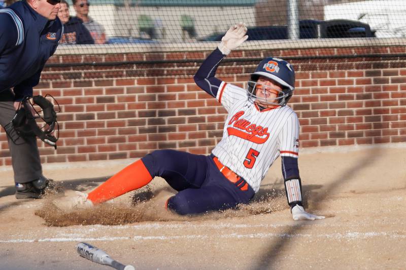 Oswego’s Marissa Moffett (5) slides into home for a score against Downers Grove South during a softball game at Oswego High School on Tuesday, March 19, 2024.