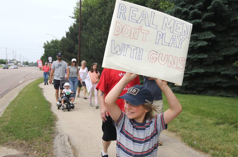 Leo Clapp, 10, from DeKalb, along with a group of around 200 protesters march north on Sycamore Road Saturday, June 11, 2022, during a March For Our Lives event that originated at Hopkins Park in DeKalb. The March For Our Lives initiative advocates for, among other things, an end to gun violence, updated gun control legislation and policy targeting gun lobbyists.