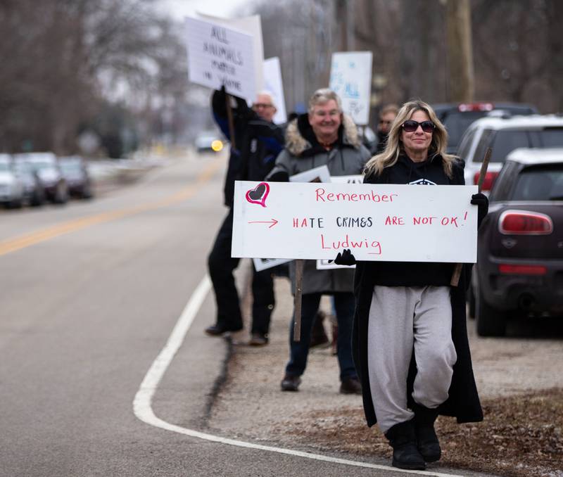 Diane Caputo of Wayne holds up signs during the Justice for Ludwig protest outside the Little Home Church by the Wayside in Wayne on Saturday, Jan. 7, 2023. Inside the church a town hall meeting took place to discuss an architectural review of the village hall and police department.