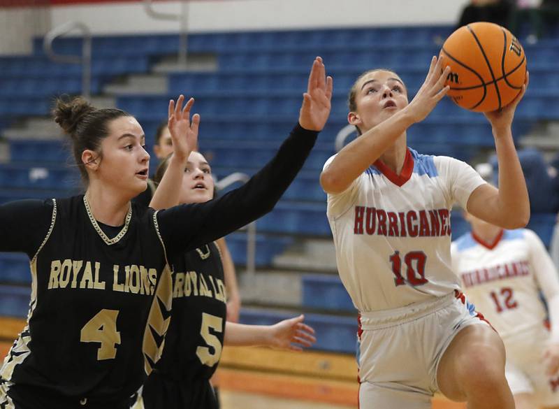 Marian Central's Adriana Wrzos (right) drives to the basket against Rockford Christian's Teagan Lawver l (left) and Shea Ludwig (center) during a nononference basketball game on Monday, Feb. 10, 2025, at Marian Central High School  in Woodstock.
